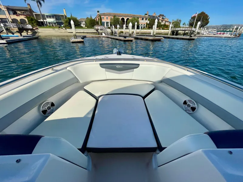 Slide: The Image of 2021 Robalo 247 Dual Console boat interior with spacious seating, docked by waterfront homes. - 16