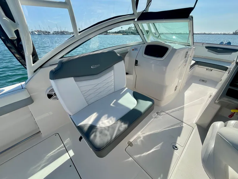 Slide: The Image of 2021 Robalo 247 Dual Console boat interior with seating and dashboard, on a sunny day. - 19