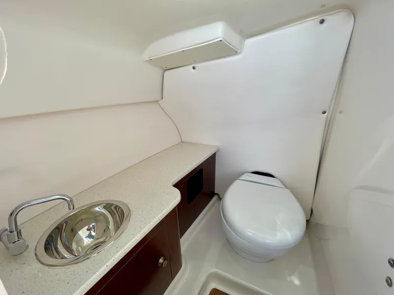 Slide: The Image of 2021 Robalo 247 Dual Console boat interior with sink and toilet. - 21