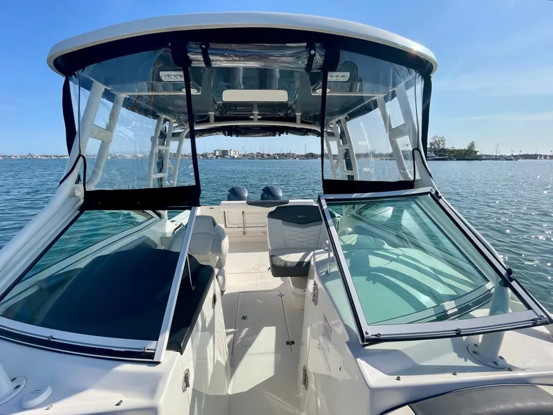Slide: The Image of 2021 Robalo 247 Dual Console boat on water, featuring spacious seating and clear windshield. - 23
