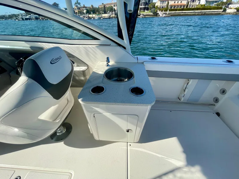 Slide: The Image of 2021 Robalo 247 Dual Console boat interior with seating and sink, overlooking water. - 26