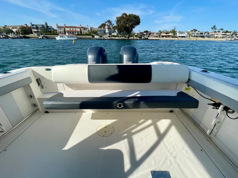 Slide: The Image of 2021 Robalo 247 Dual Console boat with twin engines on a sunny waterfront. - 28