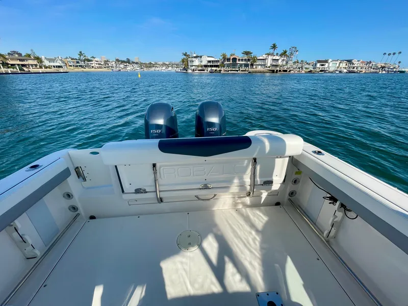 Slide: The Image of 2021 Robalo 247 Dual Console boat on water, featuring twin engines and spacious deck. - 29