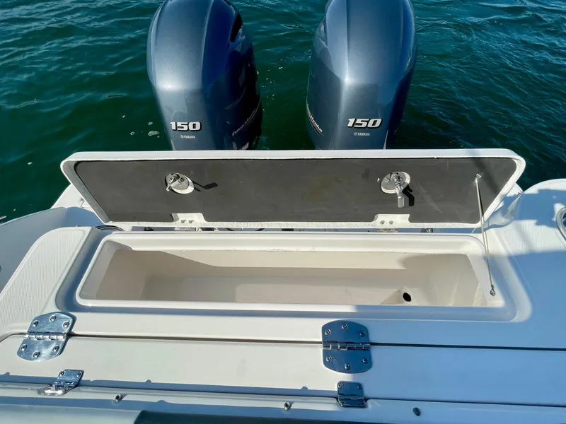 Slide: The Image of 2021 Robalo 247 Dual Console boat with open storage compartment and twin 150 horsepower engines. - 30