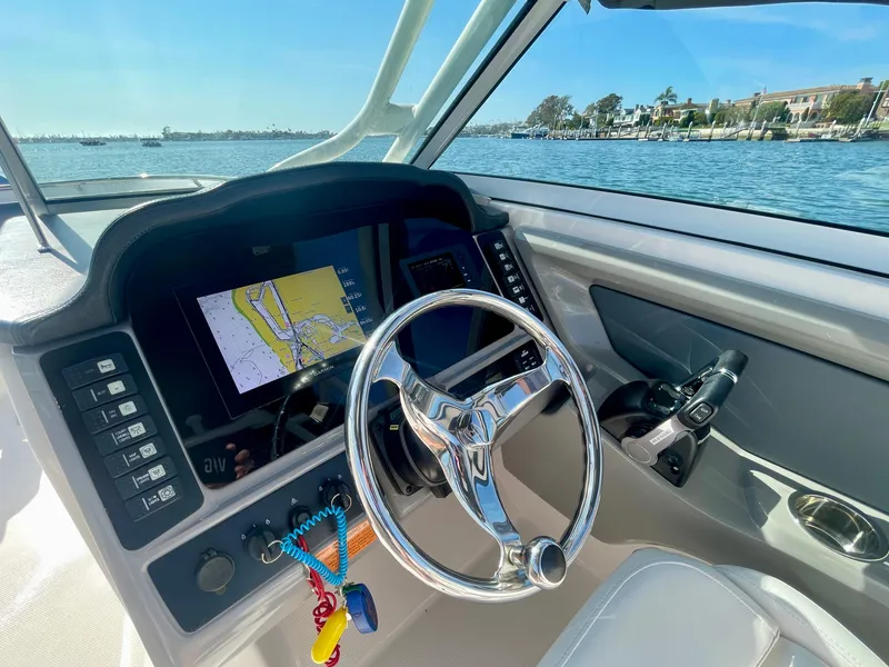 Slide: The Image of 2021 Robalo 247 Dual Console boat dashboard with navigation screen and steering wheel. - 5
