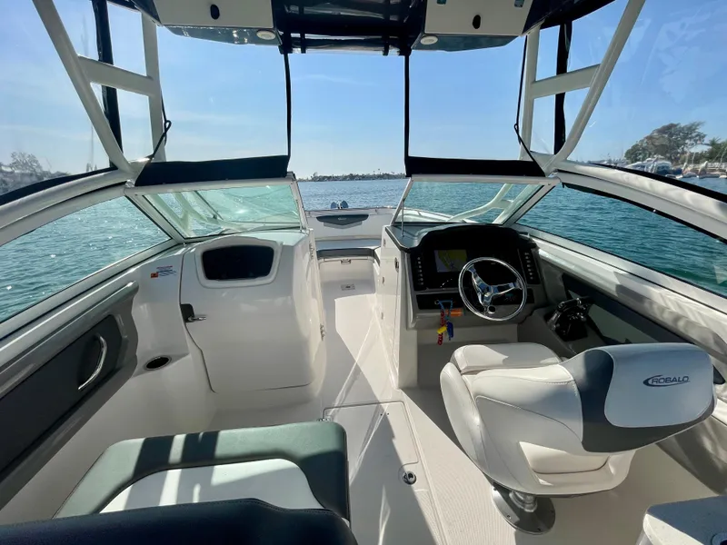 Slide: The Image of 2021 Robalo 247 Dual Console boat interior with steering wheel, seats, and open water view. - 6