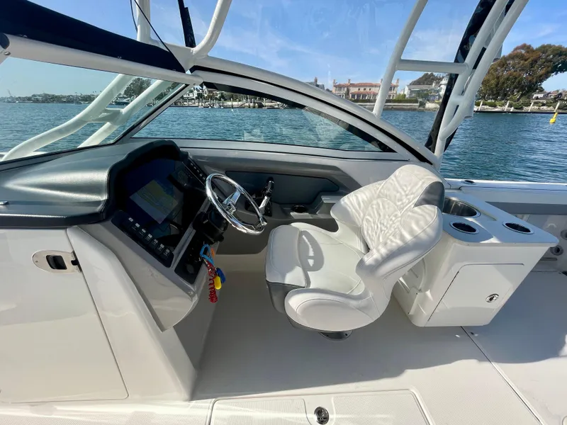 Slide: The Image of 2021 Robalo 247 Dual Console boat interior with steering wheel and comfortable seating. - 7