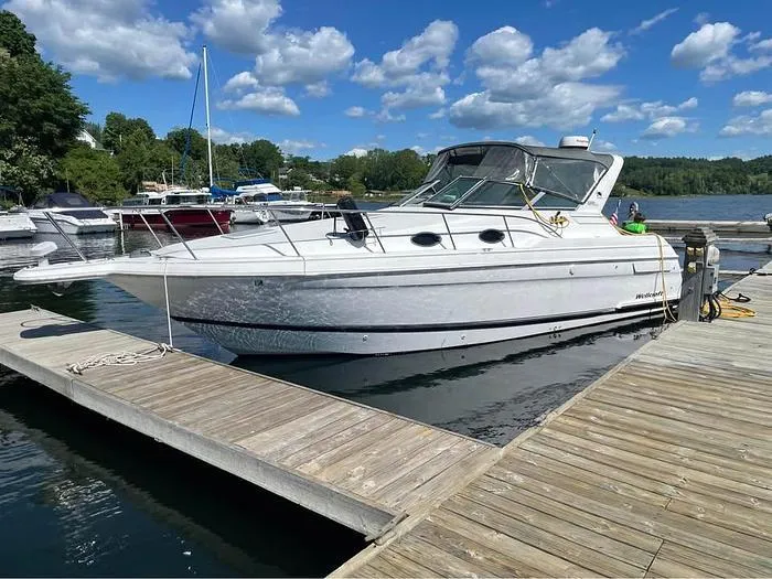 Slide: The Image of 2000 Wellcraft 3200 boat docked at marina under blue sky. - 1