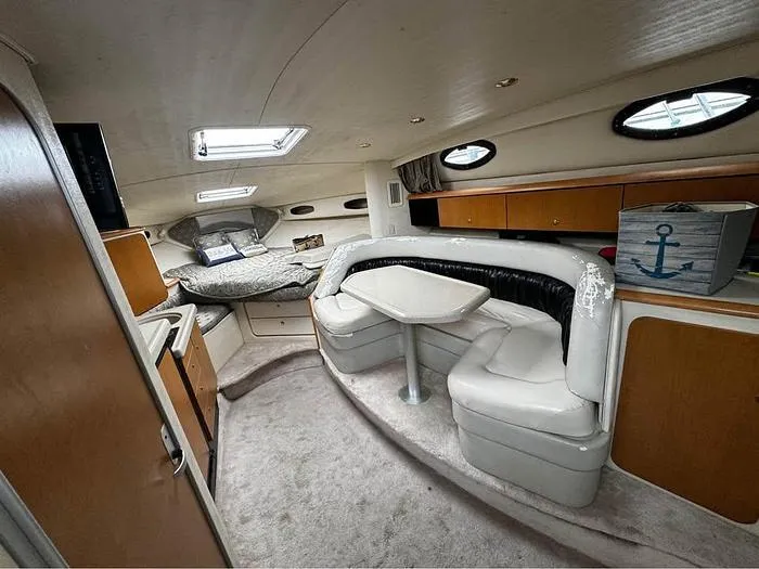 Slide: The Image of Interior of 2000 Wellcraft 3200 boat with seating, table, and cozy sleeping area. - 14