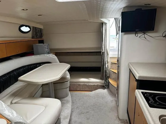 Slide: The Image of Interior of a 2000 Wellcraft 3200 boat with seating, table, and kitchenette. - 17