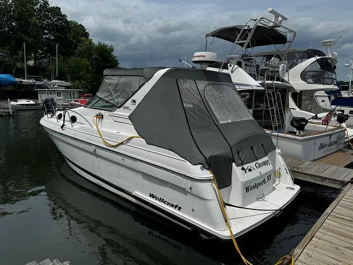 Slide: The Image of Wellcraft 3200 boat docked at marina, 2000 model, covered, overcast sky. - 2