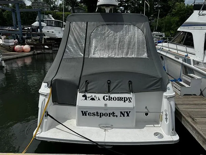 Slide: The Image of Wellcraft 3200 boat docked, rear view with cover, named "Chompy," Westport, NY. - 3