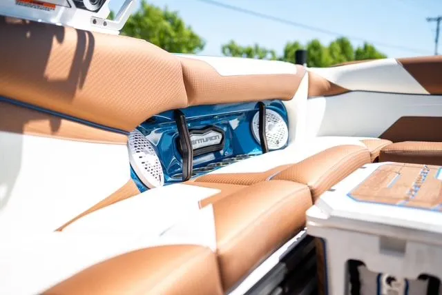 Slide: The Image of 2022 Centurion Ri265 boat interior with brown and white seating, featuring built-in speakers. - 8