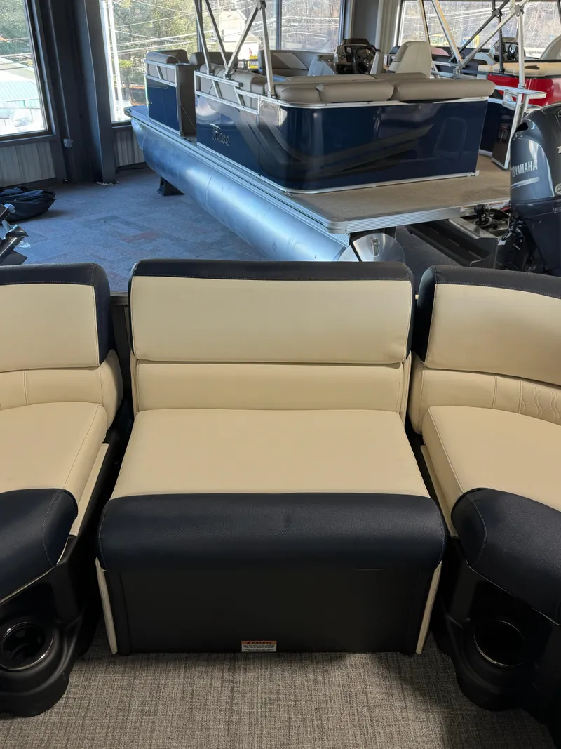 Slide: The Image of 2025 Tahoe Pontoon LTZ Versatile Rear Bench with beige and black seating in showroom. - 12