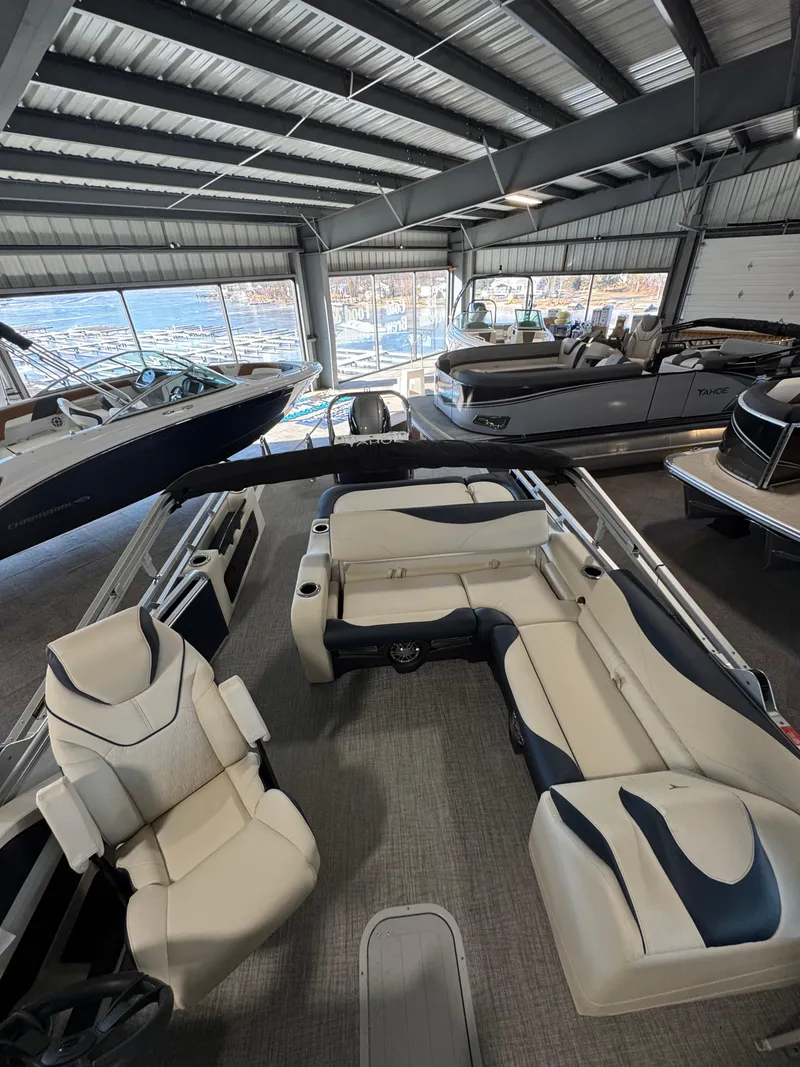 Slide: The Image of 2025 Tahoe Pontoon LTZ Versatile Rear Bench in showroom, featuring spacious seating and modern design. - 2
