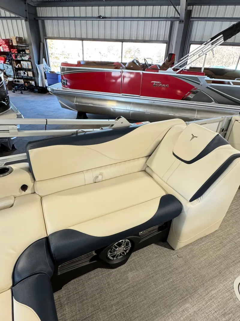 Slide: The Image of 2025 Tahoe Pontoon LTZ Versatile Rear Bench with beige and black seating in showroom. - 8