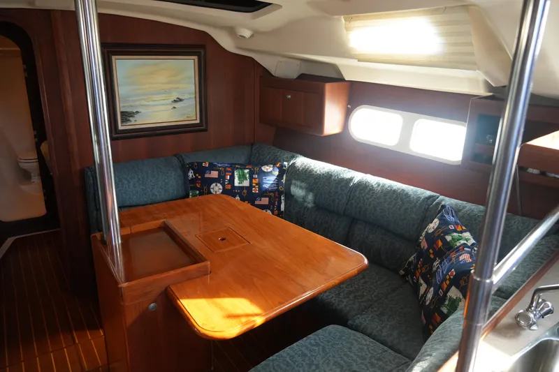 Slide: The Image of Cozy interior of 1998 Hunter 410 sailboat with wooden table and cushioned seating. - 26
