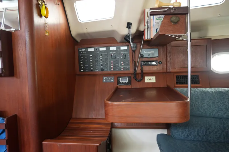 Slide: The Image of Interior of a 1998 Hunter 410 sailboat with navigation panel and seating area. - 28