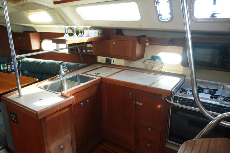 Slide: The Image of Interior of 1998 Hunter 410 sailboat kitchen with wooden cabinets and stainless steel sink. - 30