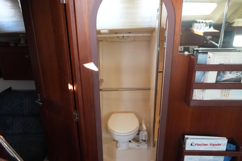 Slide: The Image of 1998 Hunter 410 yacht interior with wooden cabinetry and compact bathroom. - 31