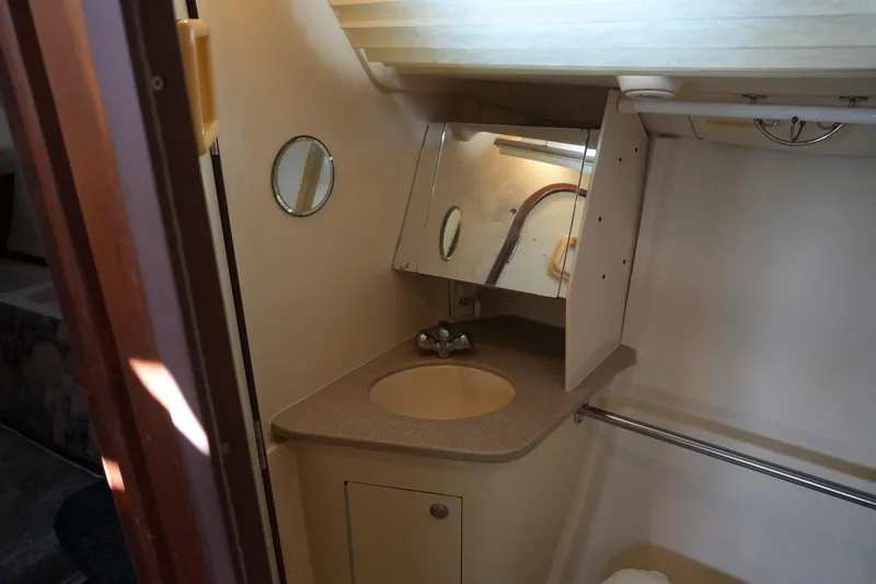 Slide: The Image of 1998 Hunter 410 yacht bathroom with sink, mirror, and storage cabinet. - 32