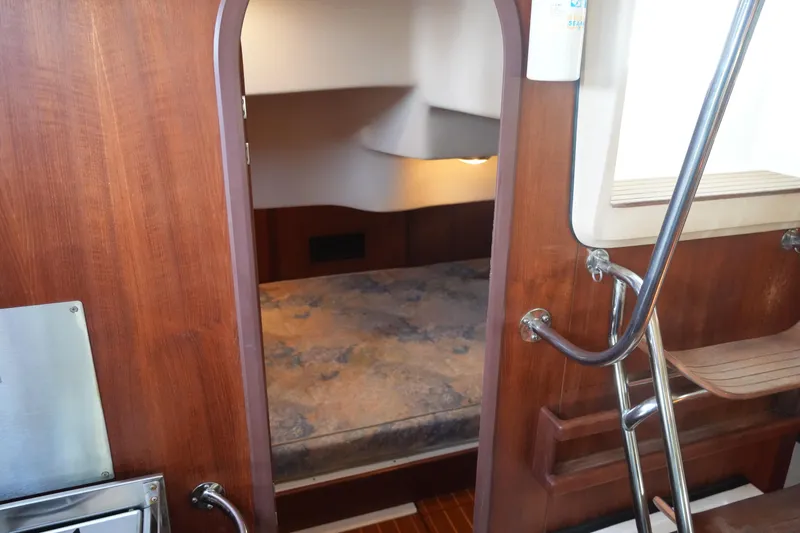 Slide: The Image of Interior cabin of a 1998 Hunter 410 sailboat with wooden finish and cozy sleeping area. - 34