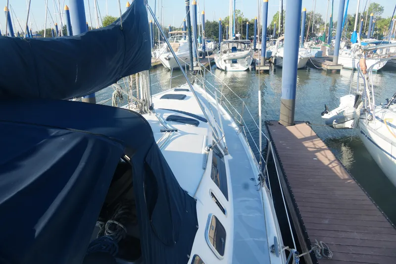 Slide: The Image of 1998 Hunter 410 sailboat docked at marina, surrounded by other boats. - 8