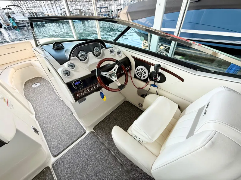 Slide: The Image of 2010 Sea Ray 250 SLX boat interior with steering wheel and dashboard, docked at marina. - 10