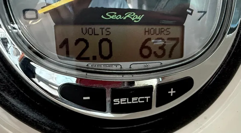 Slide: The Image of Close-up of a Sea Ray 250 SLX gauge showing 12 volts and 637 hours. - 12