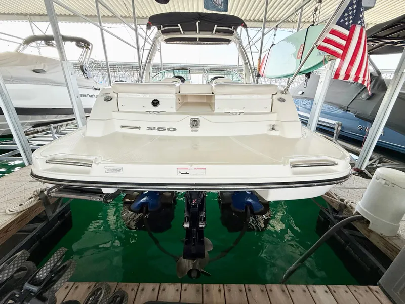Slide: The Image of 2010 Sea Ray 250 SLX boat docked, rear view with American flag. - 21