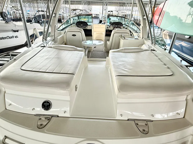 Slide: The Image of 2010 Sea Ray 250 SLX boat with spacious seating and sleek design in a marina setting. - 23