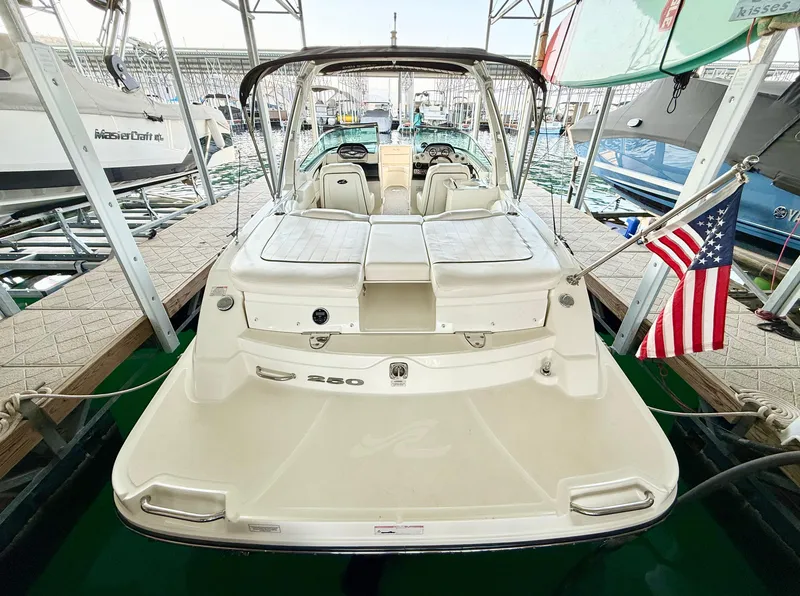 Slide: The Image of 2010 Sea Ray 250 SLX boat docked with American flag, rear view. - 28
