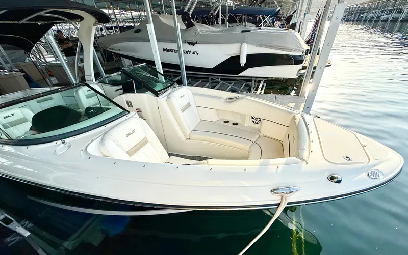 Slide: The Image of 2010 Sea Ray 250 SLX boat docked in marina, featuring sleek design and comfortable seating. - 6