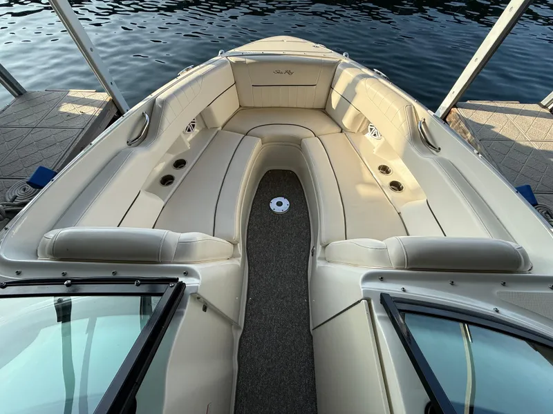 Slide: The Image of 2010 Sea Ray 250 SLX boat interior with beige seating, docked by the water. - 9