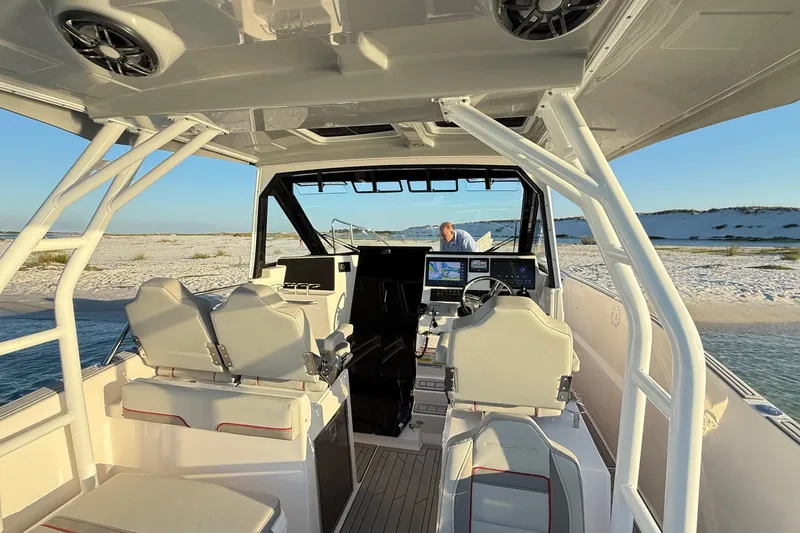 Slide: The Image of Interior of 2025 Solara S-310 CW boat with modern controls, docked on sandy beach. - 13