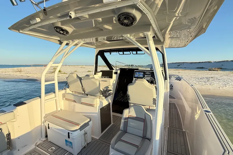 Slide: The Image of 2025 Solara S-310 CW boat interior with seating, console, and beach backdrop. - 14