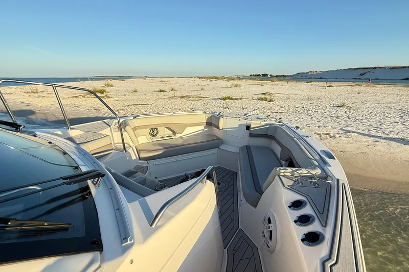 Slide: The Image of Solara S-310 CW 2025 boat docked on a sandy beach under clear blue skies. - 15