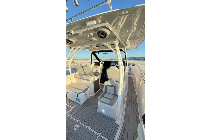 Slide: The Image of 2025 Solara S-310 CW boat interior with seating and helm, docked by the shore. - 16