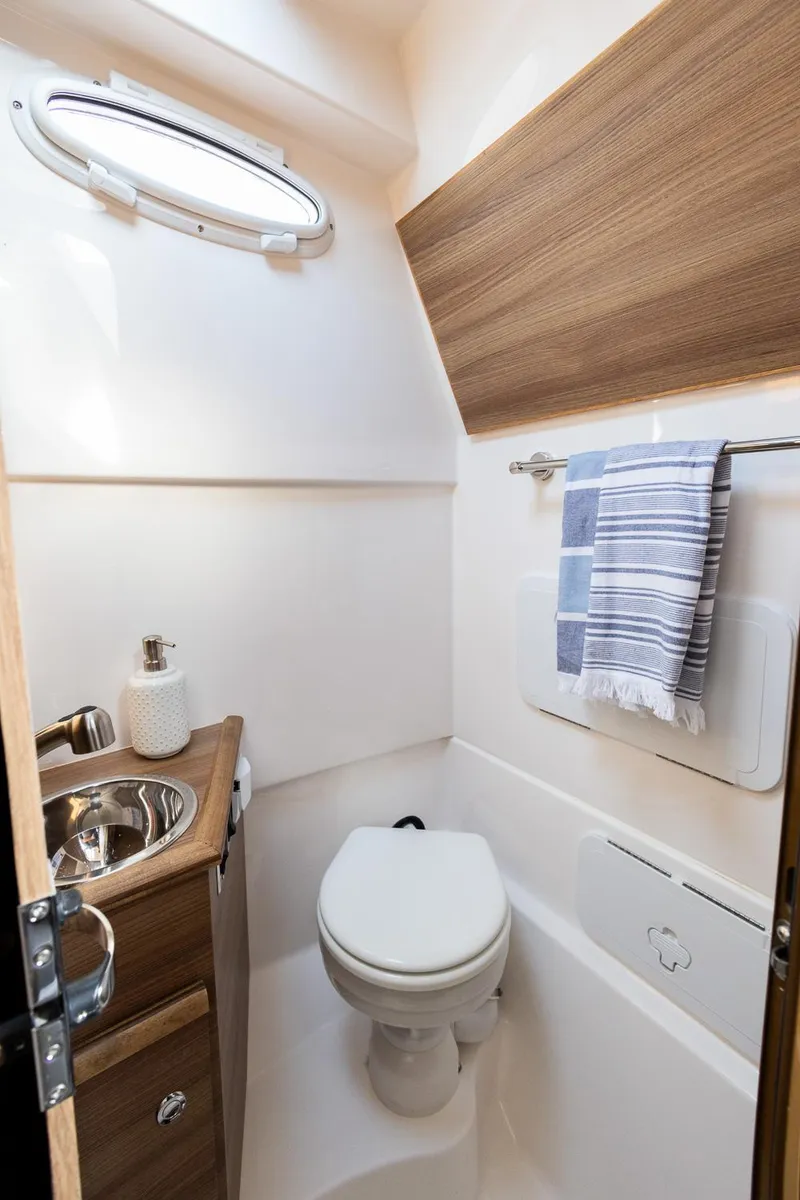 Slide: The Image of Compact bathroom in 2025 Solara S-310 CW boat with modern fixtures and wooden accents. - 32