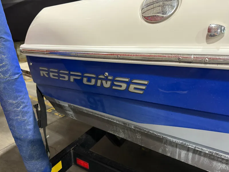 Slide: The Image of 2002 Malibu Response LX boat with blue and white exterior on a trailer. - 3