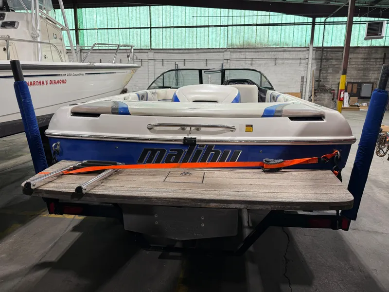 Slide: The Image of 2002 Malibu Response LX boat in a warehouse, rear view with wooden platform. - 4