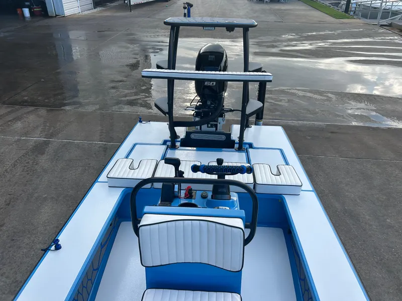 Slide: The Image of 2019 East Cape Fury boat with white and blue seating, docked on wet pavement. - 13