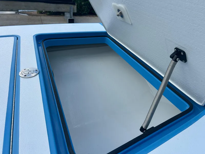 Slide: The Image of Open storage compartment on a 2019 East Cape Fury boat, featuring a blue trim. - 14