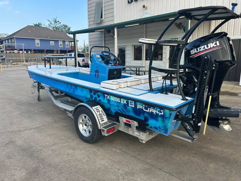 Slide: The Image of 2019 East Cape Fury boat with Suzuki engine on trailer, parked outside a building. - 4