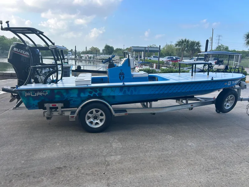 Slide: The Image of 2019 East Cape Fury boat on trailer with Suzuki outboard motor, parked near marina. - 7