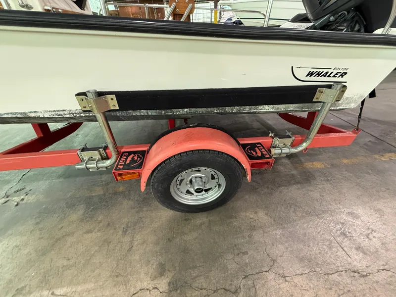 Slide: The Image of 1974 Boston Whaler 17 Montauk on red trailer, indoor storage setting. - 12