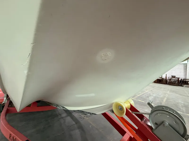 Slide: The Image of 1974 Boston Whaler 17 Montauk boat hull on red trailer in warehouse. - 13