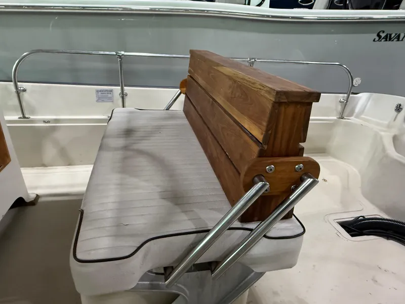 Slide: The Image of 1974 Boston Whaler 17 Montauk boat seat with wooden backrest and metal supports. - 14