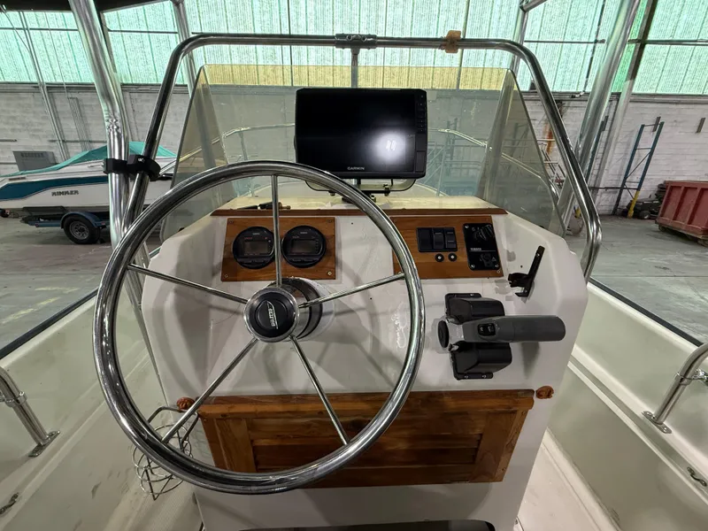 Slide: The Image of 1974 Boston Whaler 17 Montauk boat dashboard with steering wheel and navigation equipment. - 5