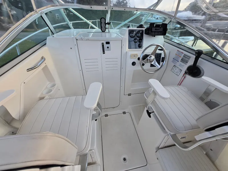 Slide: The Image of 2004 Robalo R235 Walkaround boat interior with dual seats and steering console. - 13